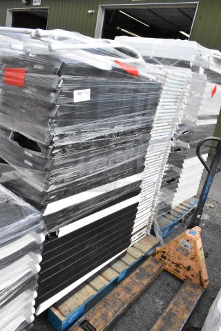 Wrapped stack of 106 folding chairs on pallets, featuring black and white frames. Numbered tag 230 visible, packaged for auction.