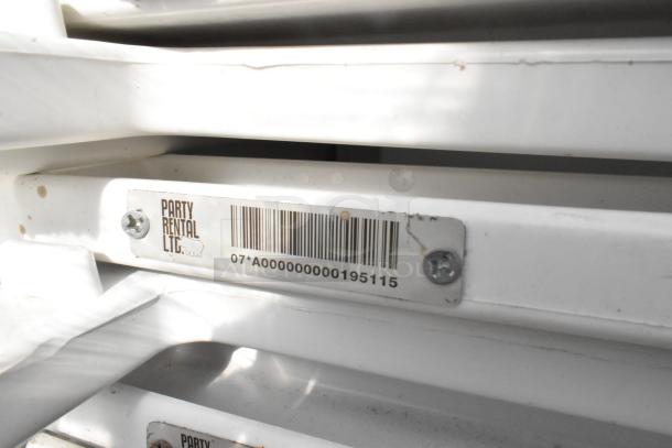 Stack of white folding chairs with visible label "Party Rental Ltd." and barcode. 90 items included. Good condition.