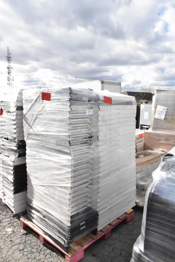 Stack of 90 folding chairs on pallet, wrapped in plastic for auction. White and black frames. Good condition.