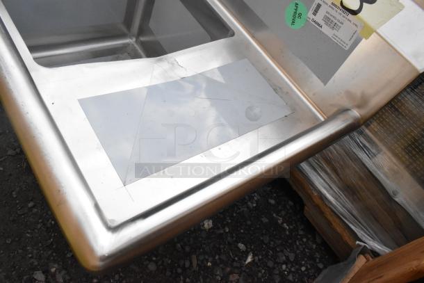 Brand new Regency 600S31416212 stainless steel three-compartment sink, 70", 16 gauge, with two drainboards. Scratch and dent condition. Marked with QC approval and product label. No legs included.