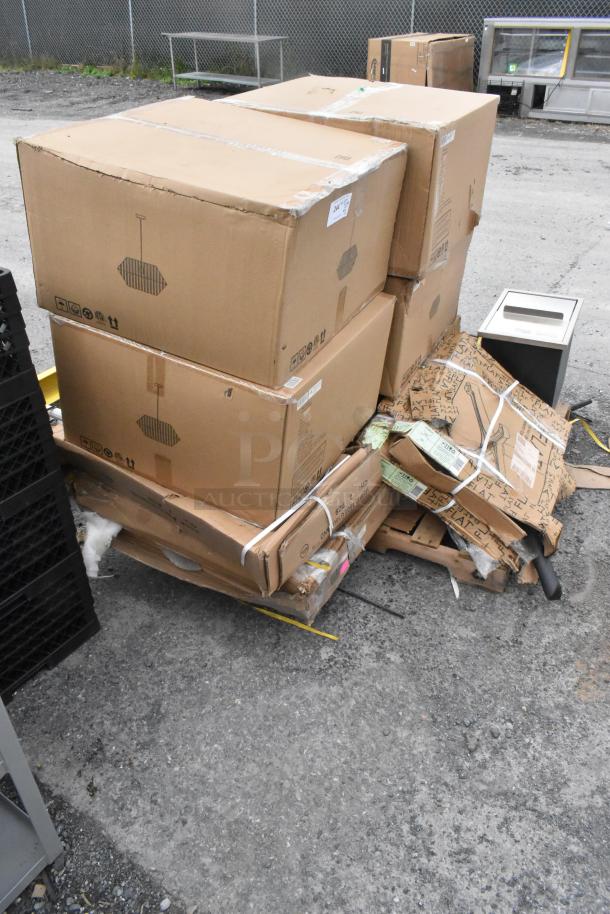 Stack of several large cardboard boxes, some labeled "Fragile," with visible scratches and dents, indicating a mixed lot of Vevor FG-SKU10 Drop In Ice Chest, Steelton 30" x 60" stainless steel stand, and 164BA3048WHT table. Boxes are on a warehouse floor.