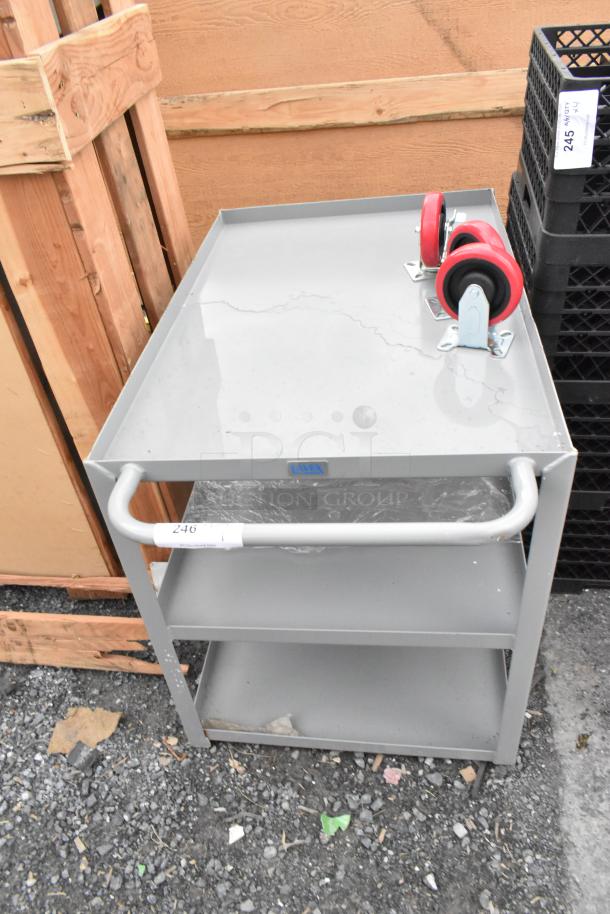 BRAND NEW Lavex gray metal 3-tier cart with 3 commercial casters, showing minor scratches. Includes labels and red wheels.