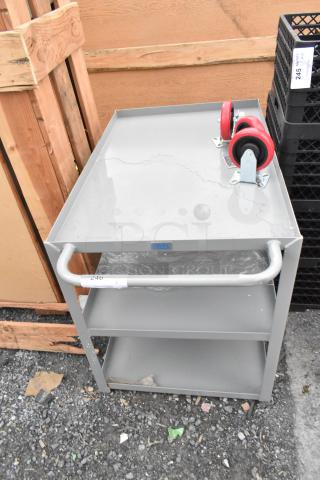BRAND NEW Lavex gray metal 3-tier cart with 3 commercial casters, showing minor scratches. Includes labels and red wheels.