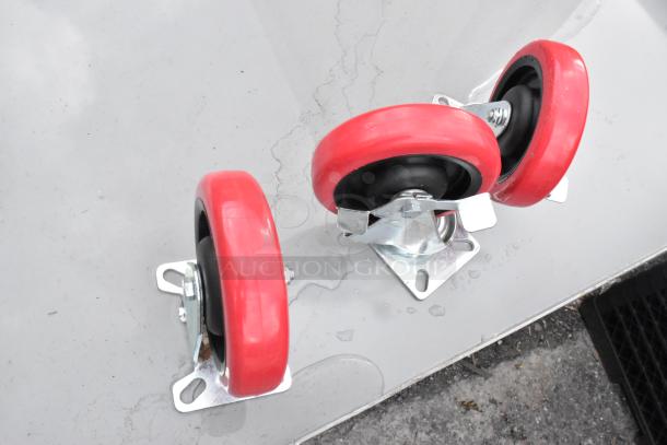 Red commercial casters for Lavex gray metal 3-tier cart. Brand new with minor scratches. Durable design for transport use.