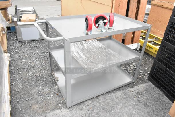 Lavex gray metal 3-tier cart with commercial casters, brand new with minor scratches, shown outdoors.