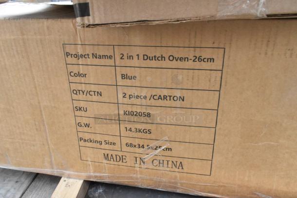 Cardboard box labeled "2 in 1 Dutch Oven-26cm," blue, 2 pieces per carton, SKU KI02058, 14.3 kgs, made in China.
