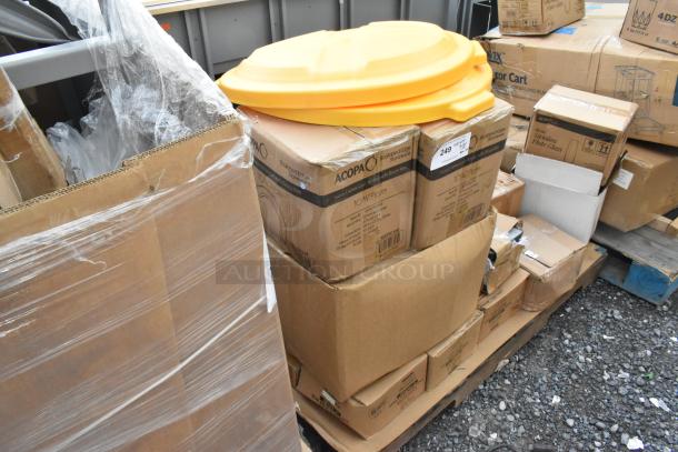 Boxes of Acopa and Carlisle merchandise atop a pallet, one labeled Acopa 10 3/4" plates, next to a yellow plastic lid.