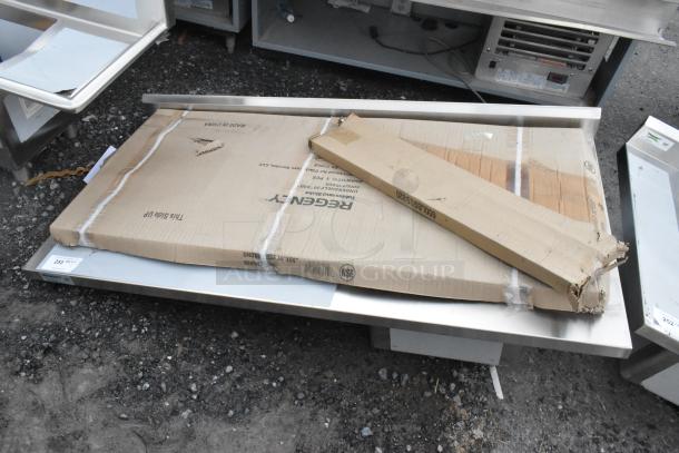 Brand new Regency 600ST3060R stainless steel table with sink basin and under-shelf in packaging, scratch and dent condition.