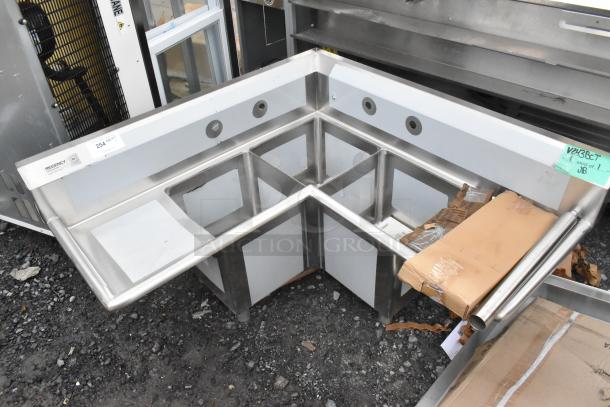 Brand new Regency 600S3141414C L-shaped stainless steel 3-bay sink with dual drain boards. Scratch and dent, no legs.