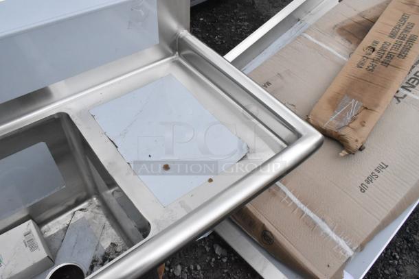 Stainless steel Regency 600S3141414C 3 bay L-shaped sink with dual drain boards, scratch and dent, no legs included.