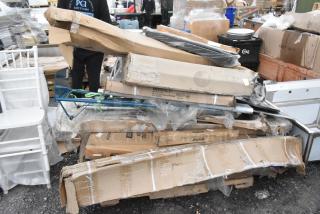 Pile of scratch and dent items including a Lancaster table base column, metalcraft market tray, Lavex hand truck, and Regency work table.