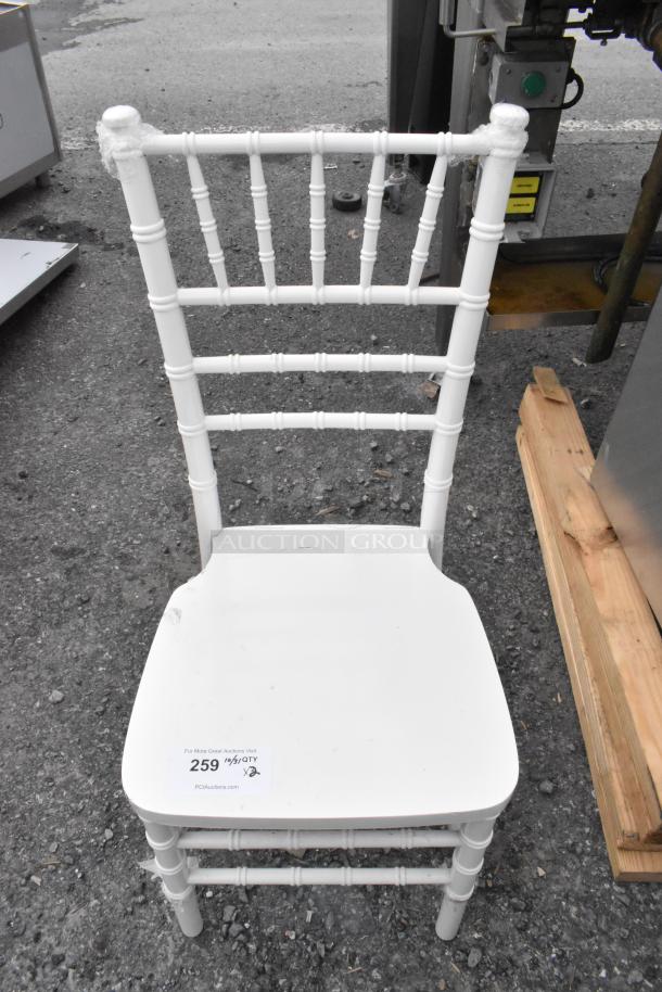 White Chiavari stackable banquet chair, brand new with some scratches and dents, stackable design, label indicating auction lot.