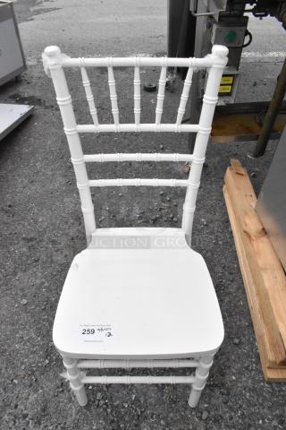 White Chiavari stackable banquet chair, brand new with some scratches and dents, stackable design, label indicating auction lot.