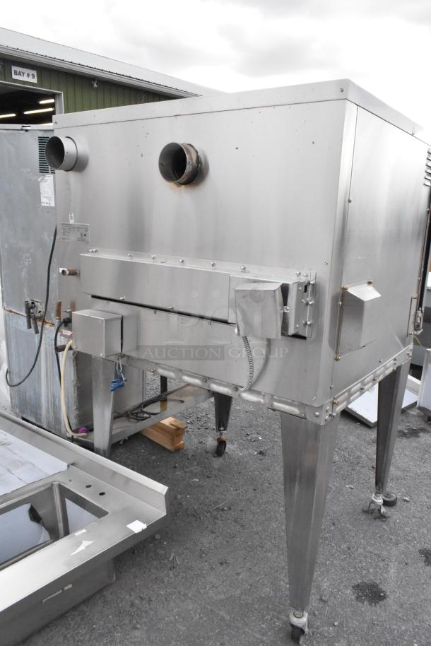 Hardt Inferno 4500 stainless steel commercial rotisserie oven, natural gas powered, with skewers, metal legs, and casters.