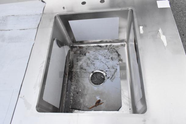 "Regency 600ST3096R stainless steel tabletop w/ sink bay, brand new, visible scratches, no legs, durable construction."