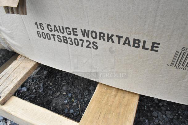 Cardboard packaging with "16-Gauge Worktable 600TSB3072S" text, indicating a stainless steel work table inside.