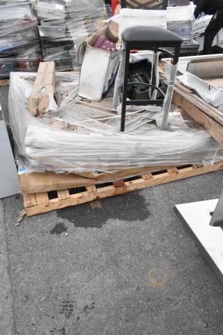 Pallet of assorted new scratch and dent items, including shelving, table bases, and a folding table, wrapped in plastic.