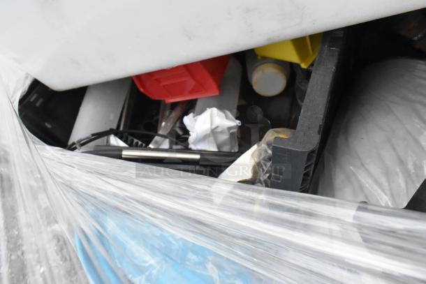 Lot of mixed items including glassware, gas hose, and metal pieces. Variety of colors and materials seen through plastic wrap.