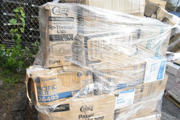 Pallet of new scratch and dent items wrapped in plastic, including Choice lids, Pacific Blue towels, and paper plates.
