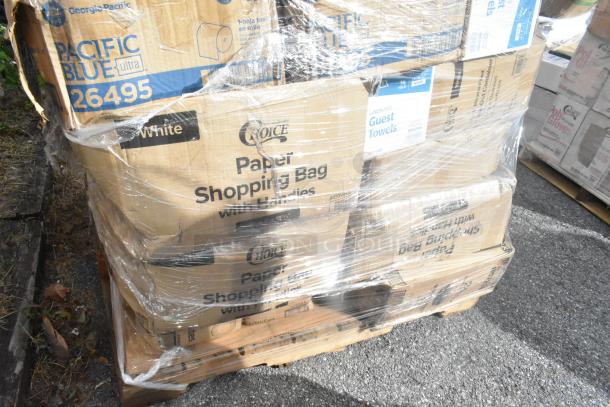 Pallet of paper bags and guest towel boxes wrapped in plastic, featuring brands like Choice and Georgia-Pacific.