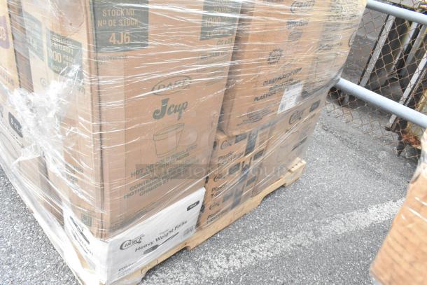 Pallet of new scratch and dent items including napkins, cold cups, and plastic forks, packaged in original boxes.
