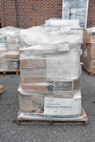 Pallet with 22 new scratch and dent items, including napkins, muffin containers, and cutlery packs wrapped in plastic.