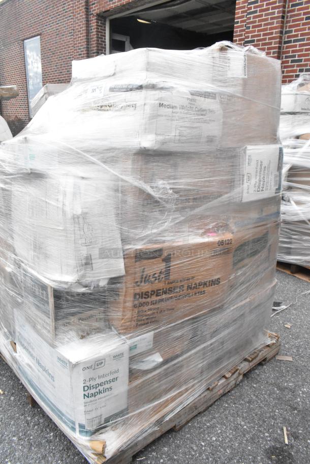 Pallet of 22 new scratch and dent items wrapped in plastic, including napkins, muffin containers, and cutlery packs.