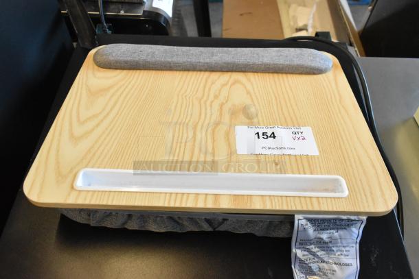 Lap tray with a wood grain top, cushioned bottom, and wrist rest. Auction label indicates quantity and auction site.