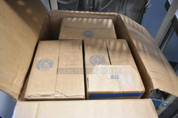 Cardboard box containing various boxed items, including Scott Foam Skin Cleanser and reams of paper, visible stamps on top.