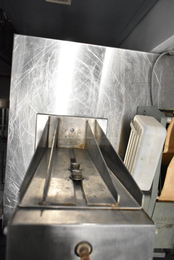 Edlund stainless steel commercial countertop unit with visible wear and scratches. Robust metal construction for kitchen use.