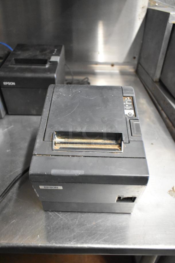 Six Epson receipt printers, models M129C, M188B, TM-T20II, black, used, visible port and label, minor wear.