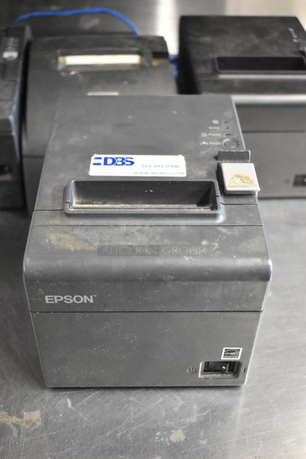 Six Epson receipt printers including models M129C, M188B, TM-T20II. Visible wear, DBS label with contact info.