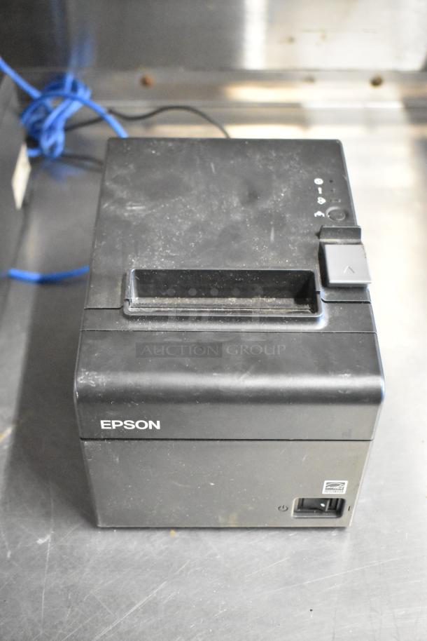 Epson receipt printer, black, model M129C. Visible wear on surface. Includes power button, logo on front.