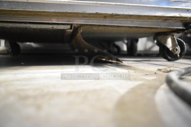 Silver King SKR27 undercounter cooler on commercial casters, stainless steel, 115V, shows wear and dirt on wheels.
