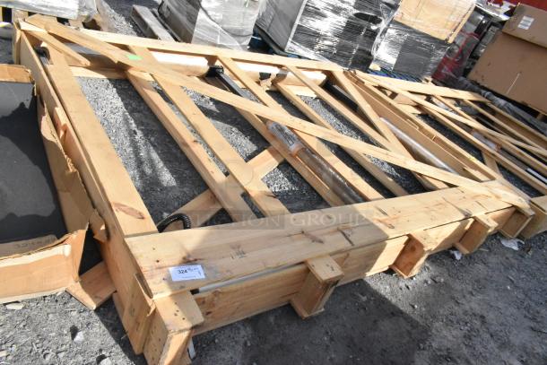 A lot of new scratch and dent shelving pieces and a 24" x 75" door in wooden frames, with tags and markings visible.