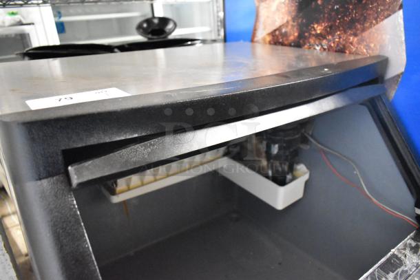 Manitowoc QY0134A stainless steel ice machine, self-contained, in used condition. Model tag visible; some wear shown.