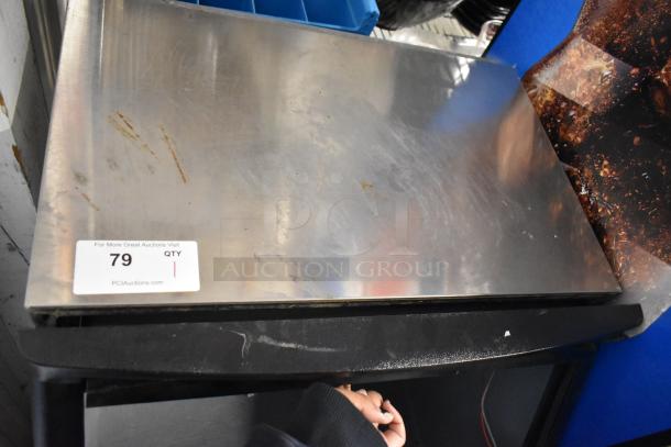 Stainless steel Manitowoc QY0134A ice machine, surface scuffs visible, auction tag states lot 79, commercial-grade.