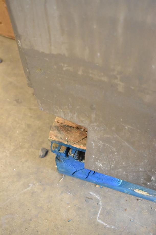 A Rational stainless steel convection oven corner on a blue wooden pallet in a warehouse setting.