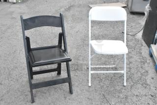 Black and white folding banquet chairs on pavement. Auction includes 106 similar chairs. Condition appears used.