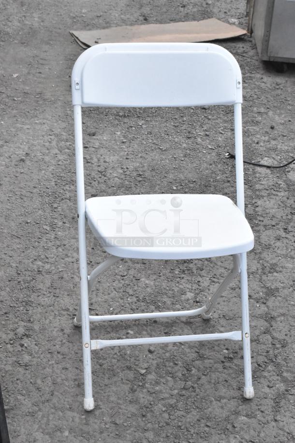 White folding banquet chair, metal frame, lightly scuffed. Part of 106-item auction lot. Suitable for events or gatherings.