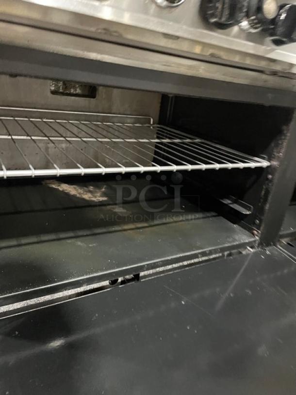 American Range commercial stainless steel 4-burner natural gas split top range, with oven, flat-griddle, and wired rack.