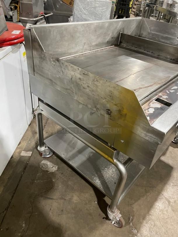 WoodStone stainless steel natural gas countertop plancha griddle on casters, with back and side splash, undershelf cart. SN: GP1B16MAY1704992.