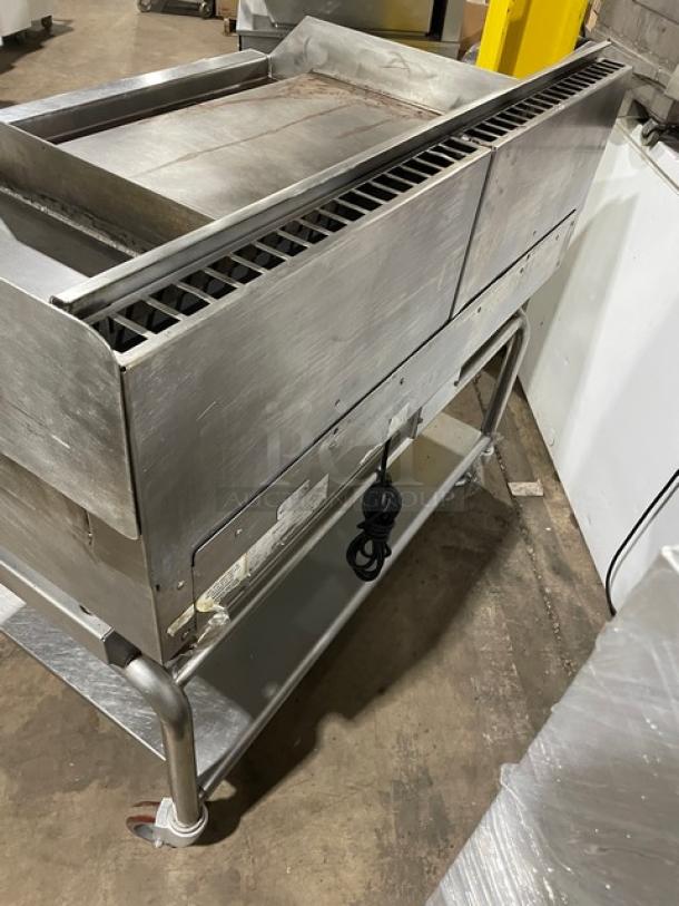 WoodStone stainless steel natural gas countertop plancha griddle with back and side splash, single undershelf cart, on casters.