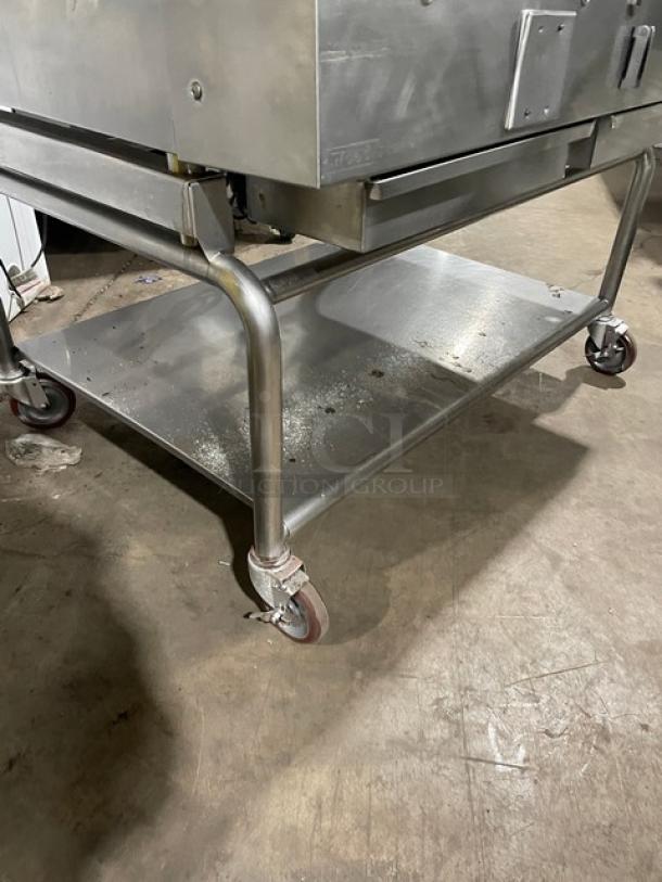 WoodStone stainless steel gas-powered plancha griddle on casters with back and side splash, featuring a single undershelf cart.