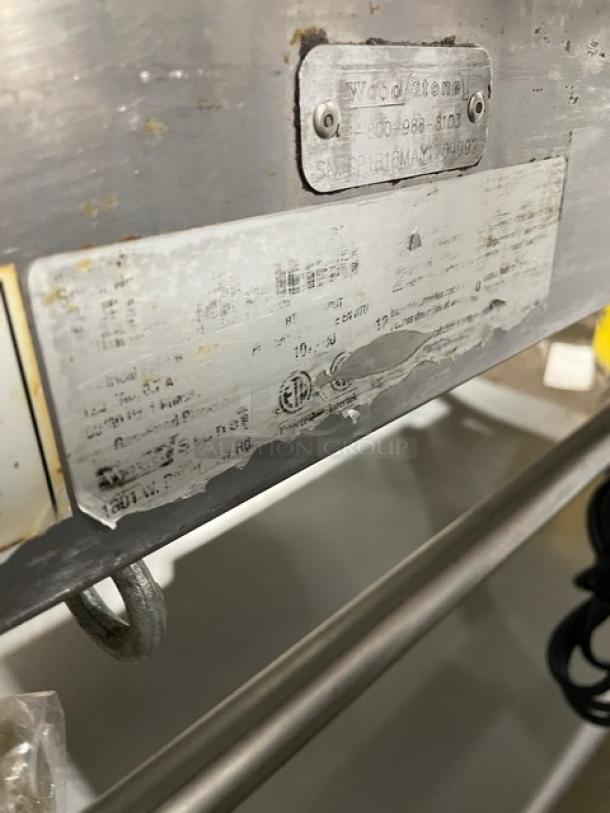 WoodStone stainless steel griddle with visible serial number plate GP1B16MAY1704992, showing minor wear.