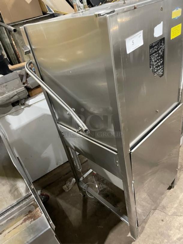 Jackson commercial stainless steel electric dishwasher, door-type, on legs, features control panel, and visible condition marks.