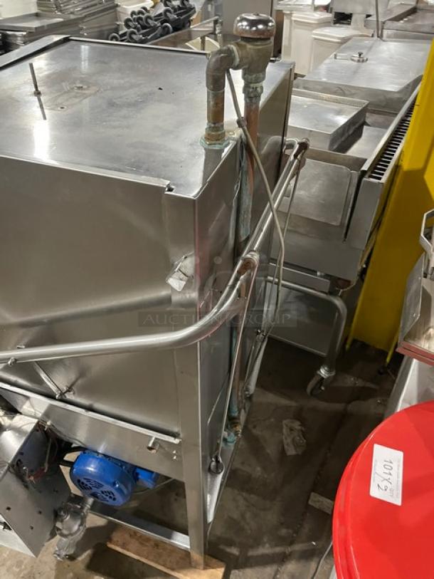 Jackson commercial stainless steel electric door-type dishwasher on legs, visible piping and motor, in used condition.