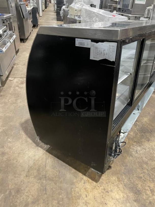 Alamo XDC200 refrigerated meat deli display, stainless steel, curved glass, poly-coated wire rack, rear sliding door.