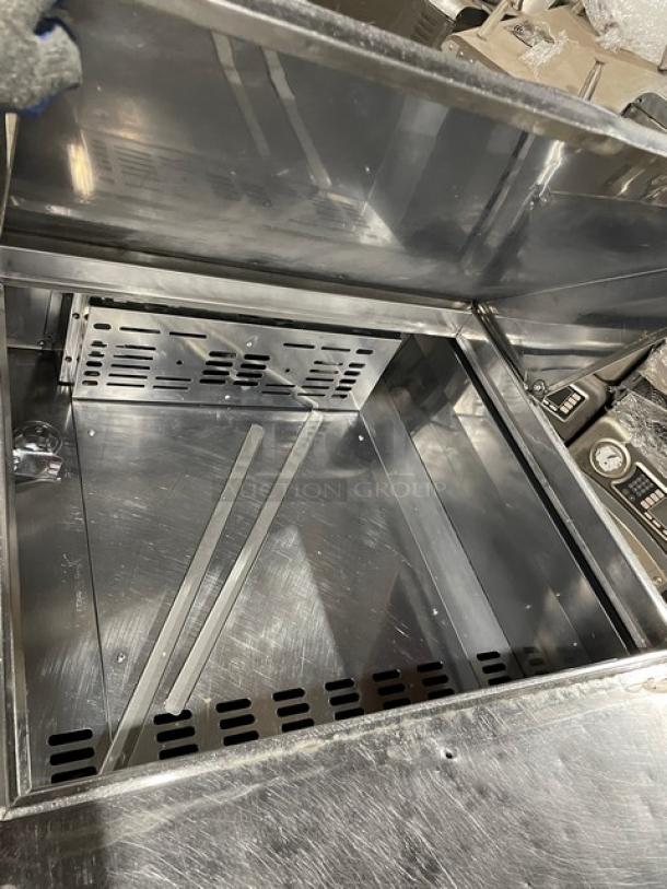 Turbo Air TST-28SD-12 stainless steel refrigerated prep table interior, includes chrome rack, on casters, excellent condition.