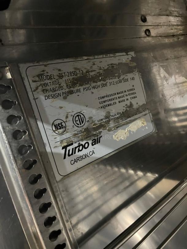 Turbo Air Super Deluxe Series Refrigerated Prep Table, Model TST-28SD-12, stainless steel, with label showing specs, on casters.